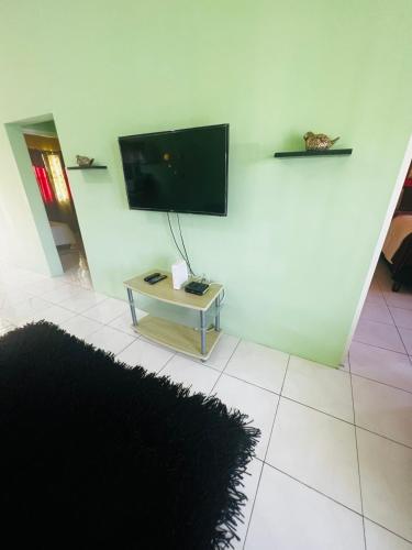 a living room with a flat screen tv on a wall at Spring Palm Estate in St Mary