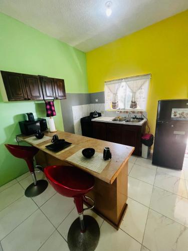 a kitchen with a wooden table and a refrigerator at Spring Palm Estate in St Mary