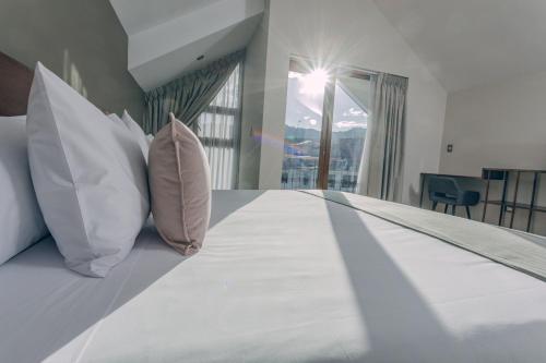a bedroom with a bed with pillows and a window at Saska Boutique Hotel in Cusco