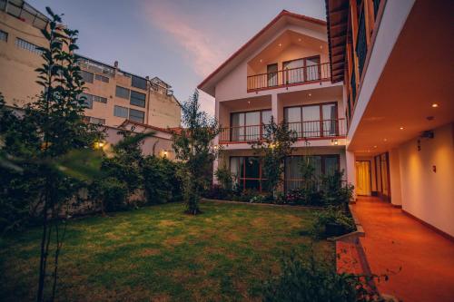 an apartment building with a lawn in the yard at Saska Boutique Hotel in Cusco