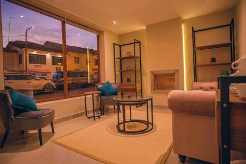 a living room with a couch and chairs and a window at Saska Boutique Hotel in Cusco