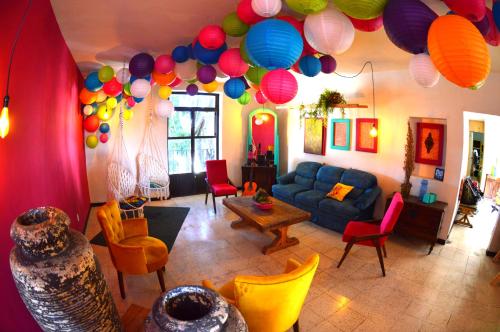 una sala de estar con globos coloridos colgando del techo en Vivir Bonito Hostal en Morelia