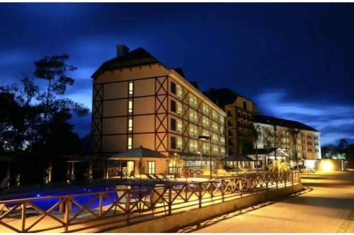 a large building at night with a fence in front of it at Condomínio VISTA AZUL in Domingos Martins