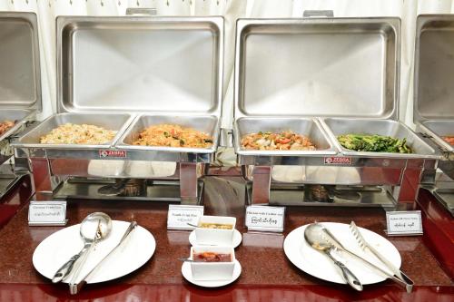 a buffet with trays of food on a table at Hotel Grand United - Chinatown in Yangon