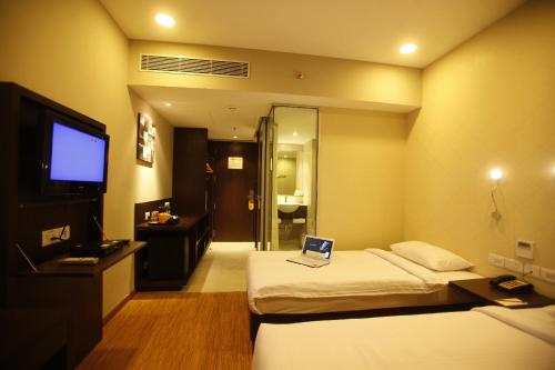 a hotel room with two beds with a laptop on it at Keys Select by Lemon Tree Hotels, Whitefield, Bengaluru in Bengaluru