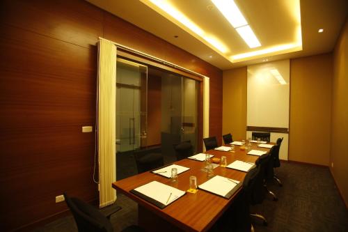 a conference room with a long wooden table and chairs at Keys Select by Lemon Tree Hotels, Whitefield, Bengaluru in Bengaluru