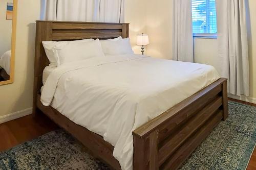 a bedroom with a large bed with white sheets at Calming Getaway 9 Mi to Clearwater Beach! in Clearwater