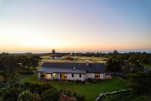 an aerial view of a white house on a green field at Manakau Lodge in Kaikoura