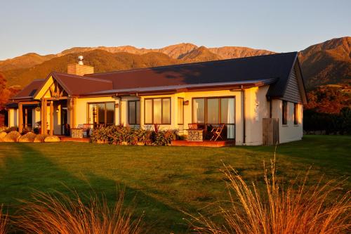 a house with mountains in the background at Manakau Lodge in Kaikoura