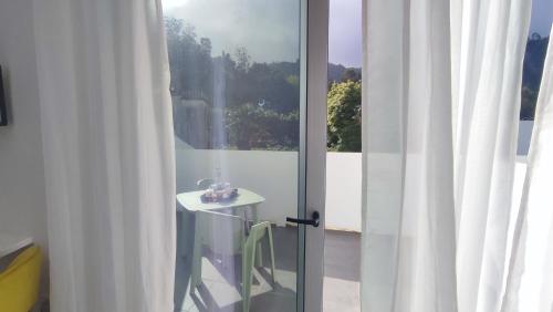 een glazen deur met een tafel naast een raam bij Atlantic 3 Bicas - Furnas in Furnas