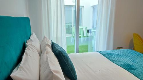 sypialnia z łóżkiem z poduszkami i oknem w obiekcie Atlantic 3 Bicas - Furnas w mieście Furnas