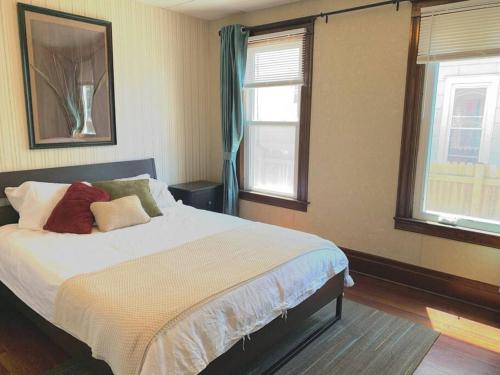 a bedroom with a bed and two windows at Cute and cozy at Niagara Falls USA in Niagara Falls