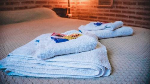 duas toalhas brancas em cima de uma cama em Hotel alamos de la puntilla em Belén