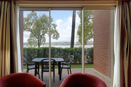 a patio with a table and chairs in front of a window at BOCA DO RIO - Apartamento 109 in Estômbar
