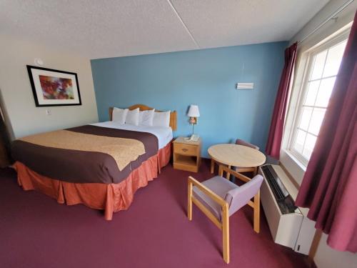 a hotel room with a bed and a table at Spinning Wheel Inn in Branson