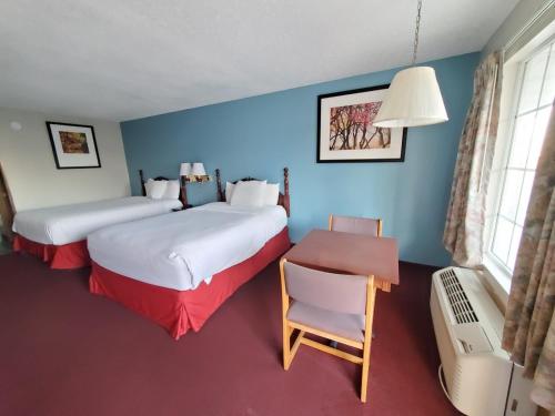 a room with two beds and a table and a chair at Twelve Oaks Inn in Branson