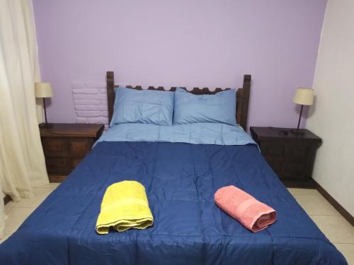 Una cama azul con dos toallas encima. en Tu Cabaña, en San Martín de los Andes