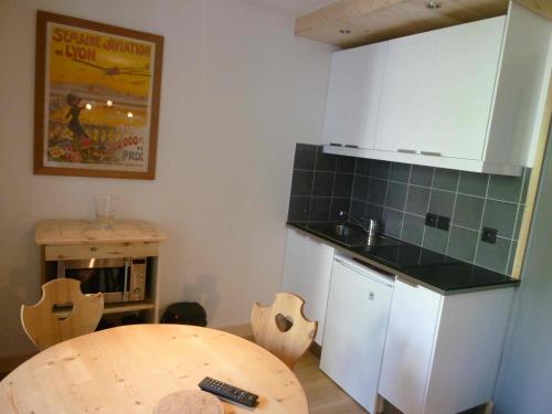a kitchen with a table and a sink and a counter top at Hôtel Rent in Megève
