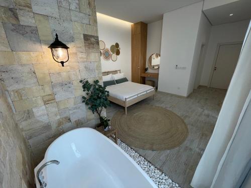 Habitación con baño con bañera y sofá. en شاليهات قصيد الفندقية, en Buraidah