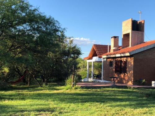 an old brick house in a field with a tree at Tacko Huasi in San Javier