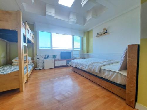 a bedroom with a large bed and a large window at Nice View Guesthouse in Seogwipo