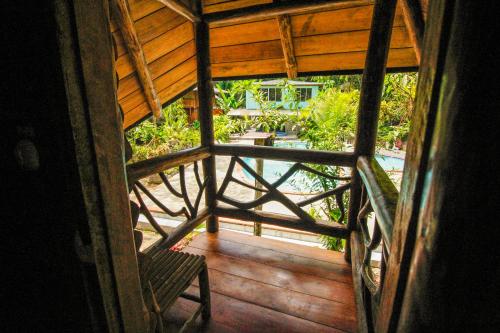 an outside view of a wooden porch with a bench at Hosteria Flor de Canela in Puyo