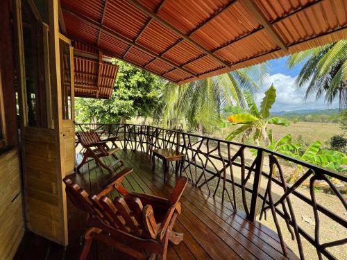 - une terrasse couverte avec des chaises et une vue sur un champ dans l'établissement Hacienda Rio Oro, à Agua Buena