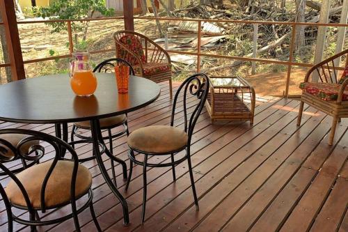 una mesa y sillas en un porche con zumo de naranja en Casa Jacinto en San Juanillo