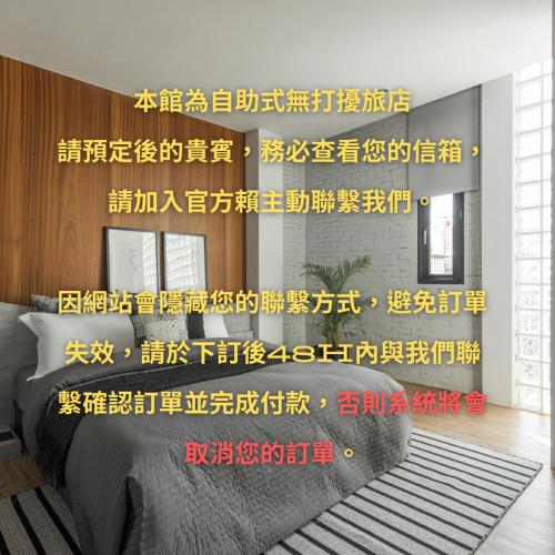 a room with a bed and a wall with writing on it at H suite Go in Changhua City