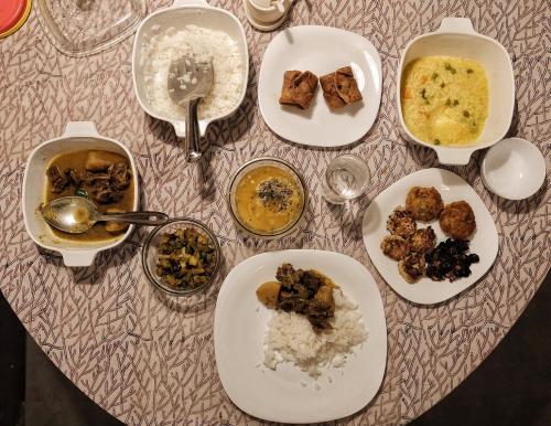 ein Tisch mit Tellern voller Essen auf einem Tisch in der Unterkunft PARUL - Elegant Heritage Home at the Heart of Shantiniketan in Shānti Niketan
