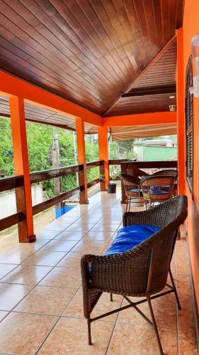 a room with chairs and a piano on a porch at Pousada Arco Íris in Abraão