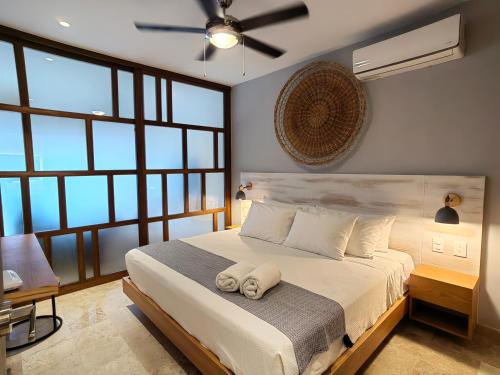 a bedroom with a bed with two towels on it at IPANA Luxury Apartments by Vacaciones.Yeah in Playa del Carmen
