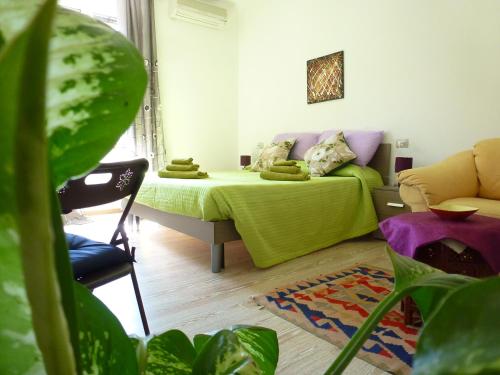 1 dormitorio con 1 cama con manta verde en B&B Luce Viola, en Dorgali