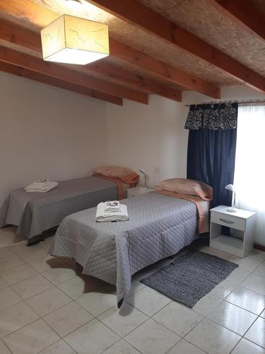 1 dormitorio con 2 camas en una habitación con ventana en Hospedaje Naim en Ushuaia