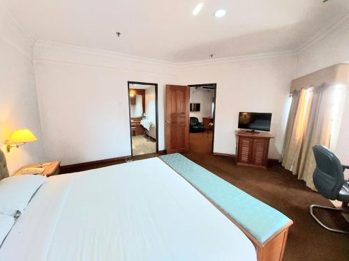 a bedroom with a large bed and a television at Sutera Inn Prima Hotel in Kota Bharu
