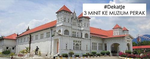太平HOMESTAY CIK MUNAH的一座白色的大建筑,有红色的屋顶