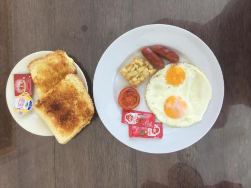 2 Teller mit Frühstückslebensmittel mit Eierwurst und Toast in der Unterkunft Kartika Villas in Lovina