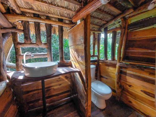 a bathroom with a sink and a toilet in a cabin at SAYON RIVER COTTAGE & ECO GARDEN in Monaragala