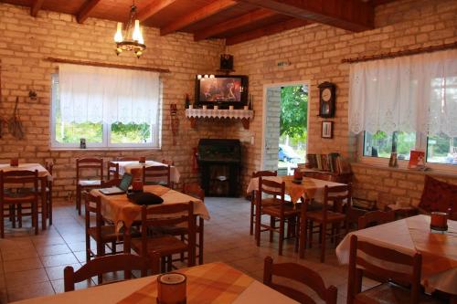 a restaurant with tables and chairs and a fireplace at Amarantos in Loutra Amarantou