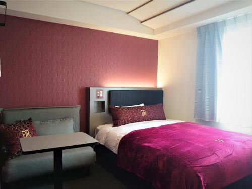 a bedroom with a bed and a table and a window at Green Rich Hotel Matsue Station Across - Artificial hot spring Futamata Yunohana in Matsue