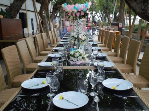 a long table with plates and wine glasses on it at Singaraja Hotel - CHSE Certified in Singaraja