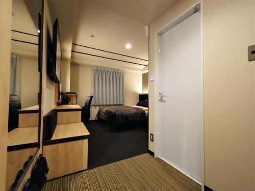 a hotel room with a bed and a television at Green Rich Hotel Matsue Station Across - Artificial hot spring Futamata Yunohana in Matsue