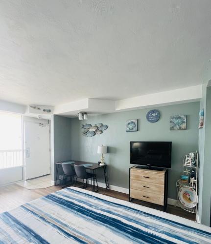 a bedroom with a large bed and a flat screen tv at Daytona Beach Resort Oceanfront CondoStudio in Daytona Beach