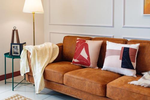 a brown couch with pillows on it in a living room at Sunrise Gurney in George Town
