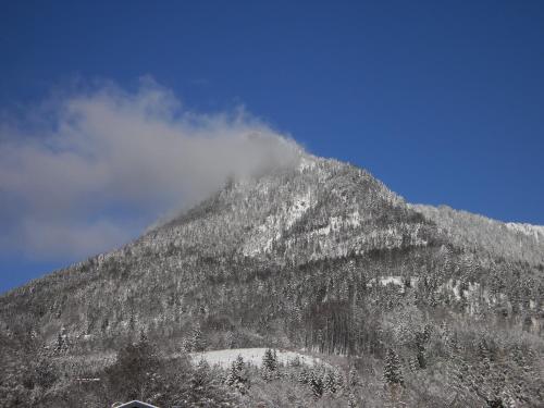a mountain covered in snow with a cloud on it at Pension Salzburger Hof in Fuschl am See