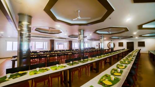 グルヴァイアールにあるHotel Guruvayur Darshanの長いテーブルと食べ物を用意したダイニングルーム