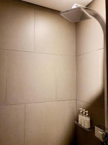 a bathroom with a white tiled wall and a light at JS Boutique Hotel in Hwaseong