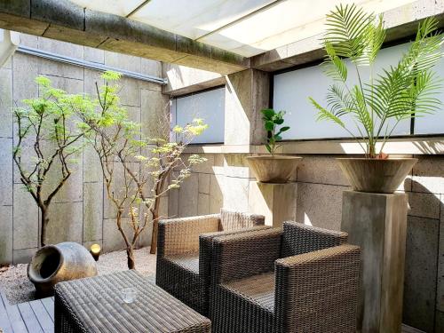 a patio with wicker chairs and a table and plants at JS Boutique Hotel in Hwaseong