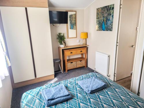 um quarto com uma cama com duas almofadas azuis em Dog Friendly 6 Berth Static Caravan Newquay em Newquay