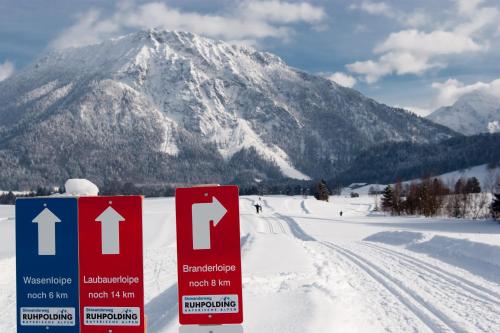 a sign in the snow in front of a mountain at Landhotel Maiergschwendt inkl Chiemgaukarte in Ruhpolding